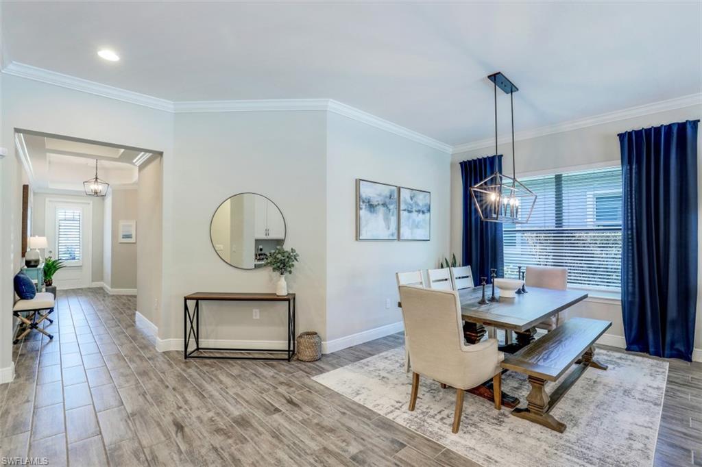 3528 Pilot Circle Naples, FL 34120 - Photo 10 of 46 a dining room with furniture a potted plant and wooden floor