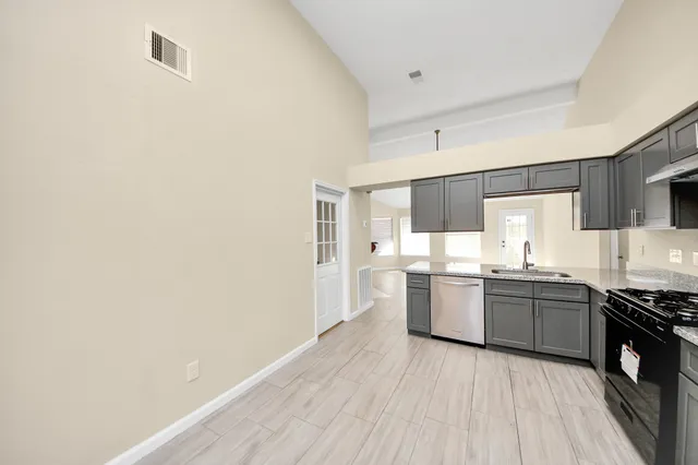 a large kitchen with a wooden floor and stainless steel appliances