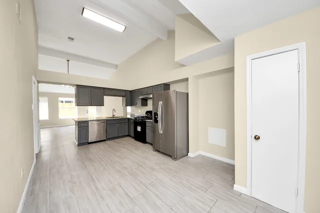 a kitchen with stainless steel appliances a sink and a refrigerator