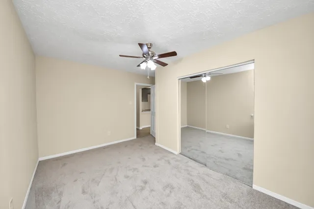 a view of an empty room with a ceiling fan