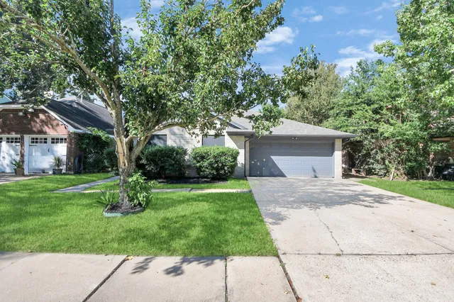 a front view of a house with a yard and trees