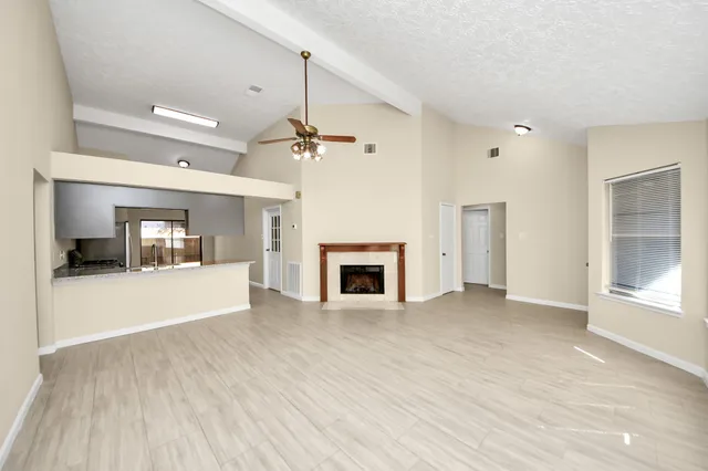 an empty room with windows and fireplace