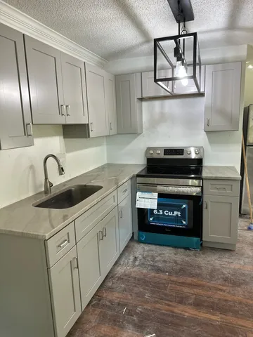 a kitchen with stainless steel appliances granite countertop a sink stove and cabinets