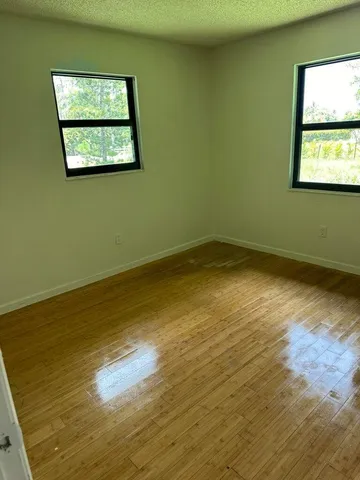 a view of a room with wooden floor and a window