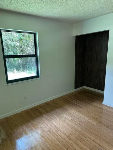 an empty room with wooden floor and a window