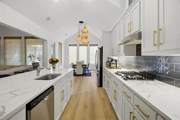 a kitchen with stove a sink and cabinets