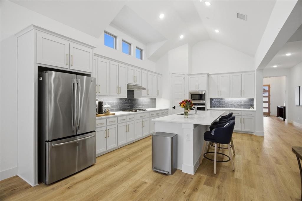 6033 Strada Cove Fort Worth, TX 76123 - Photo 14 of 35 a kitchen with stainless steel appliances granite countertop a refrigerator a sink dishwasher a stove and white cabinets with wooden floor