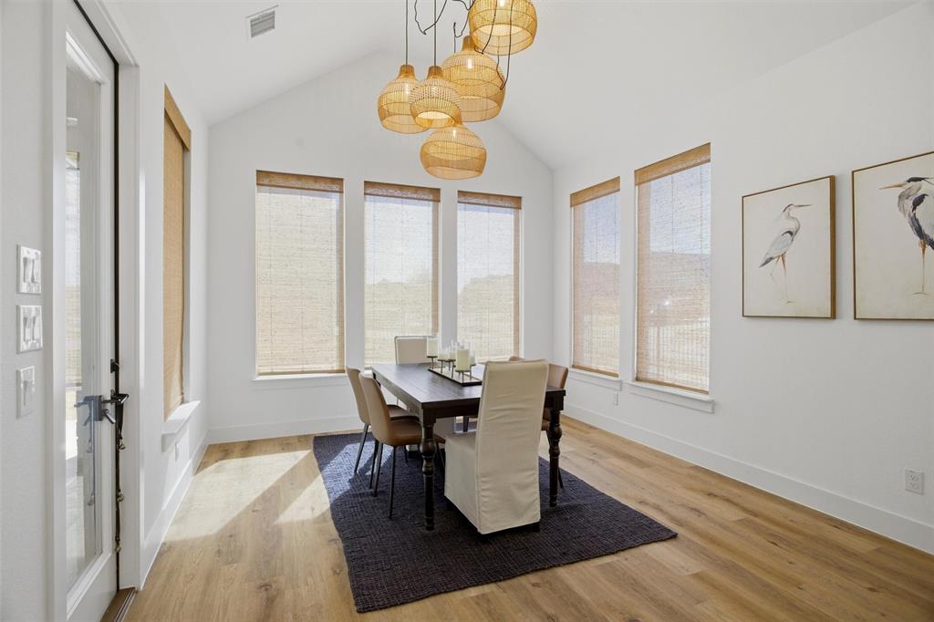 6033 Strada Cove Fort Worth, TX 76123 - Photo 16 of 35 a dining room with wooden floor a chandelier a glass table and chairs