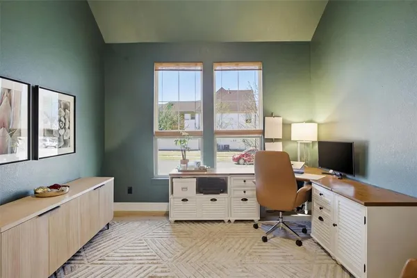 a view of a workspace with furniture and a window