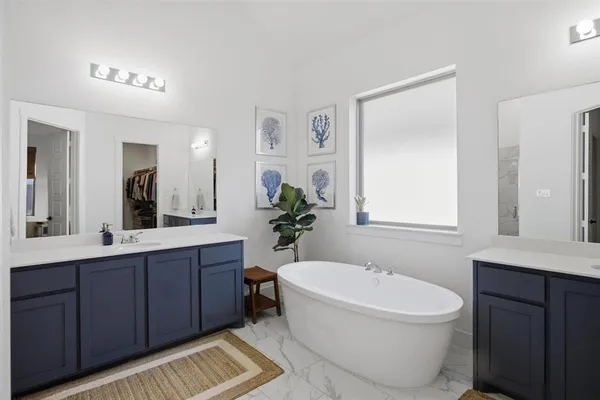 a bathroom with a toilet a sink a mirror a bathtub and vanity
