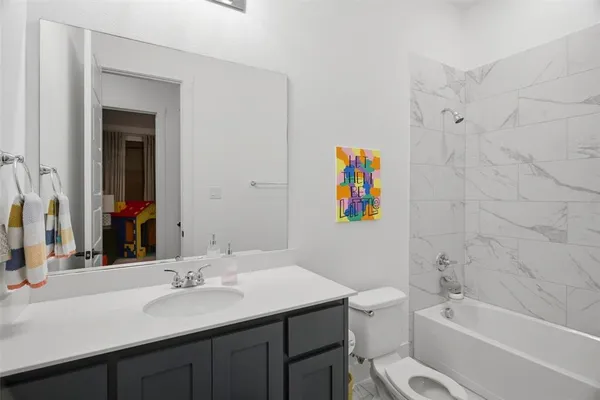 a bathroom with a granite countertop sink a toilet and shower