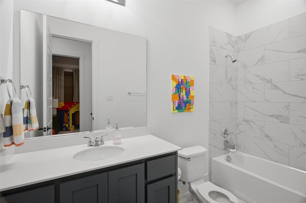 6033 Strada Cove Fort Worth, TX 76123 - Photo 28 of 35 a bathroom with a granite countertop sink a toilet and shower