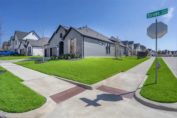 a view of a big house with a big yard and potted plants