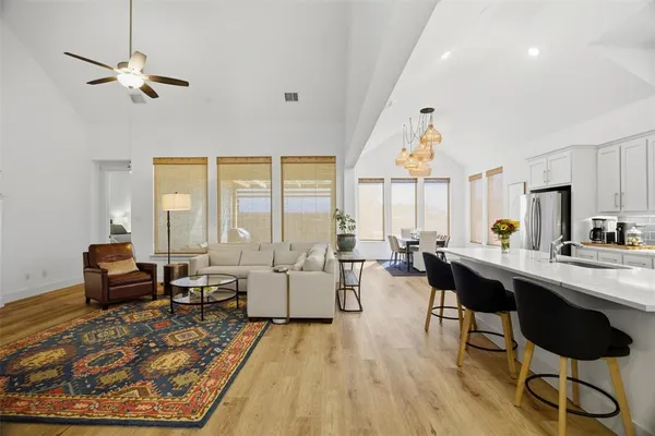 a living room with furniture large window and wooden floor