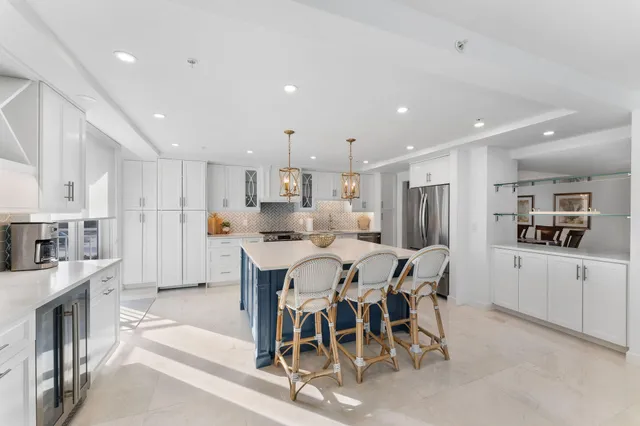 a large kitchen with dining table chairs and a refrigerator
