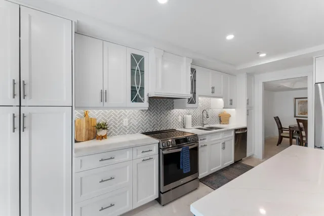 a kitchen with granite countertop white cabinets and white appliances