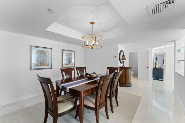 a dining room with furniture a chandelier and window