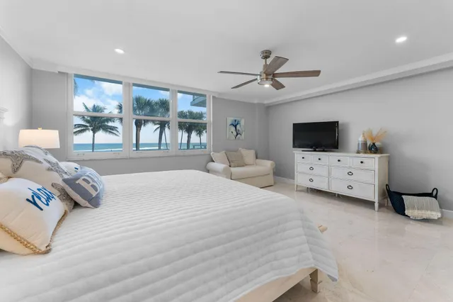 a spacious bedroom with a bed and a flat screen tv