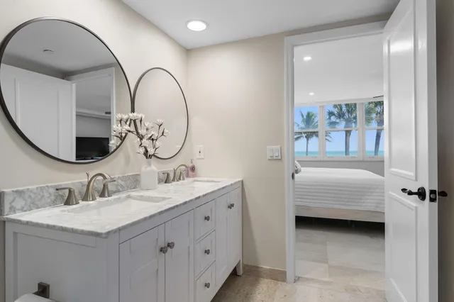 a en suite bathroom with a granite countertop sink and a mirror