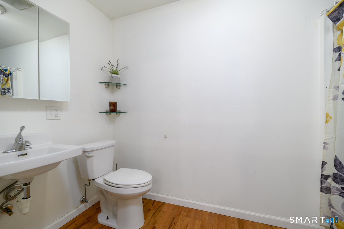 800 Seaview Avenue, Unit 8001 Bridgeport, CT 06607 - Photo 16 of 25 a bathroom with a toilet a sink and mirror