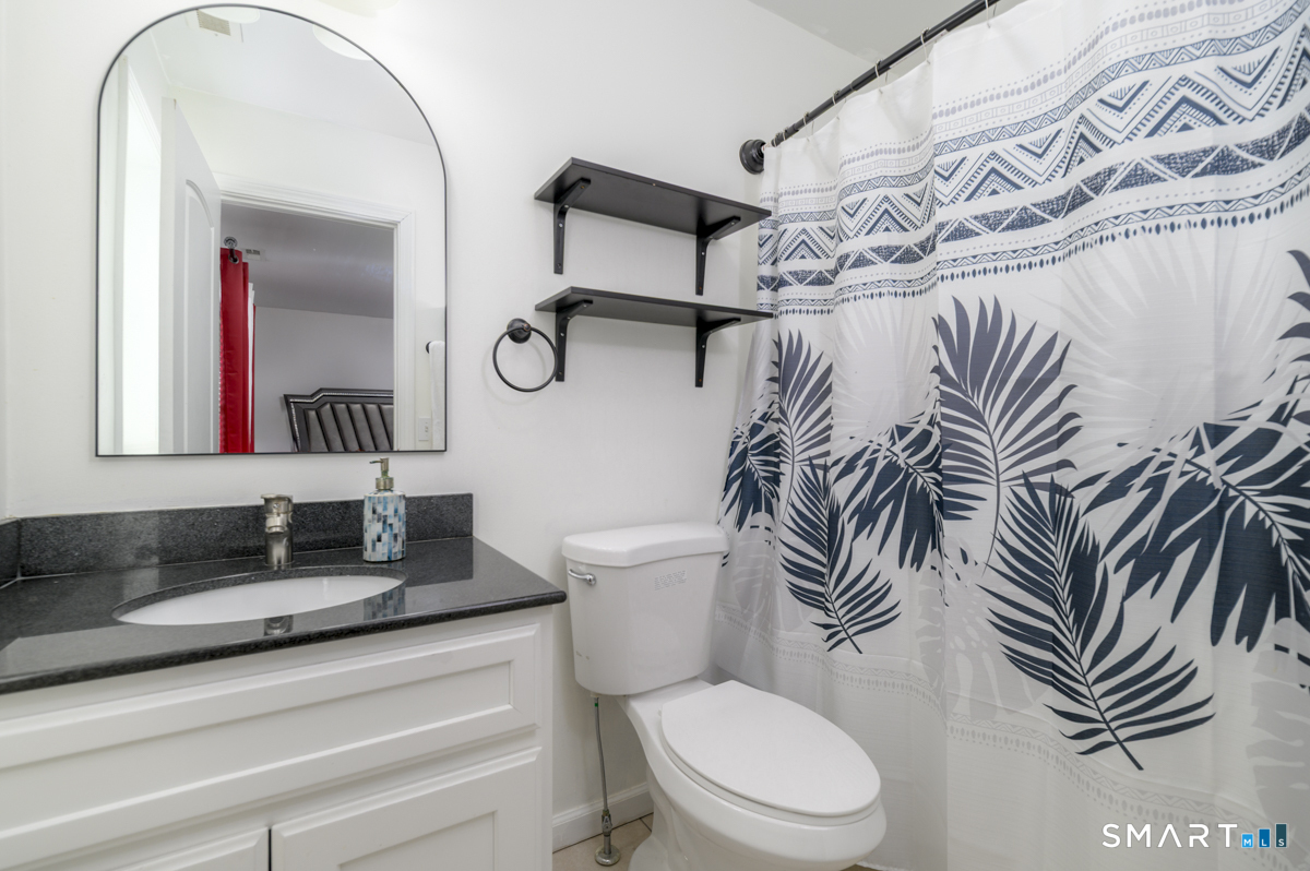 800 Seaview Avenue, Unit 8001 Bridgeport, CT 06607 - Photo 19 of 25 a bathroom with a granite countertop sink a toilet and a mirror