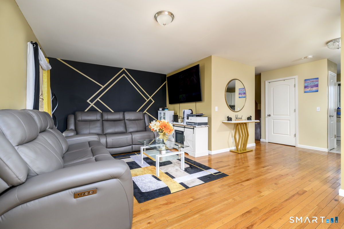 800 Seaview Avenue, Unit 8001 Bridgeport, CT 06607 - Photo 6 of 25 a living room with furniture a flat screen tv and kitchen view