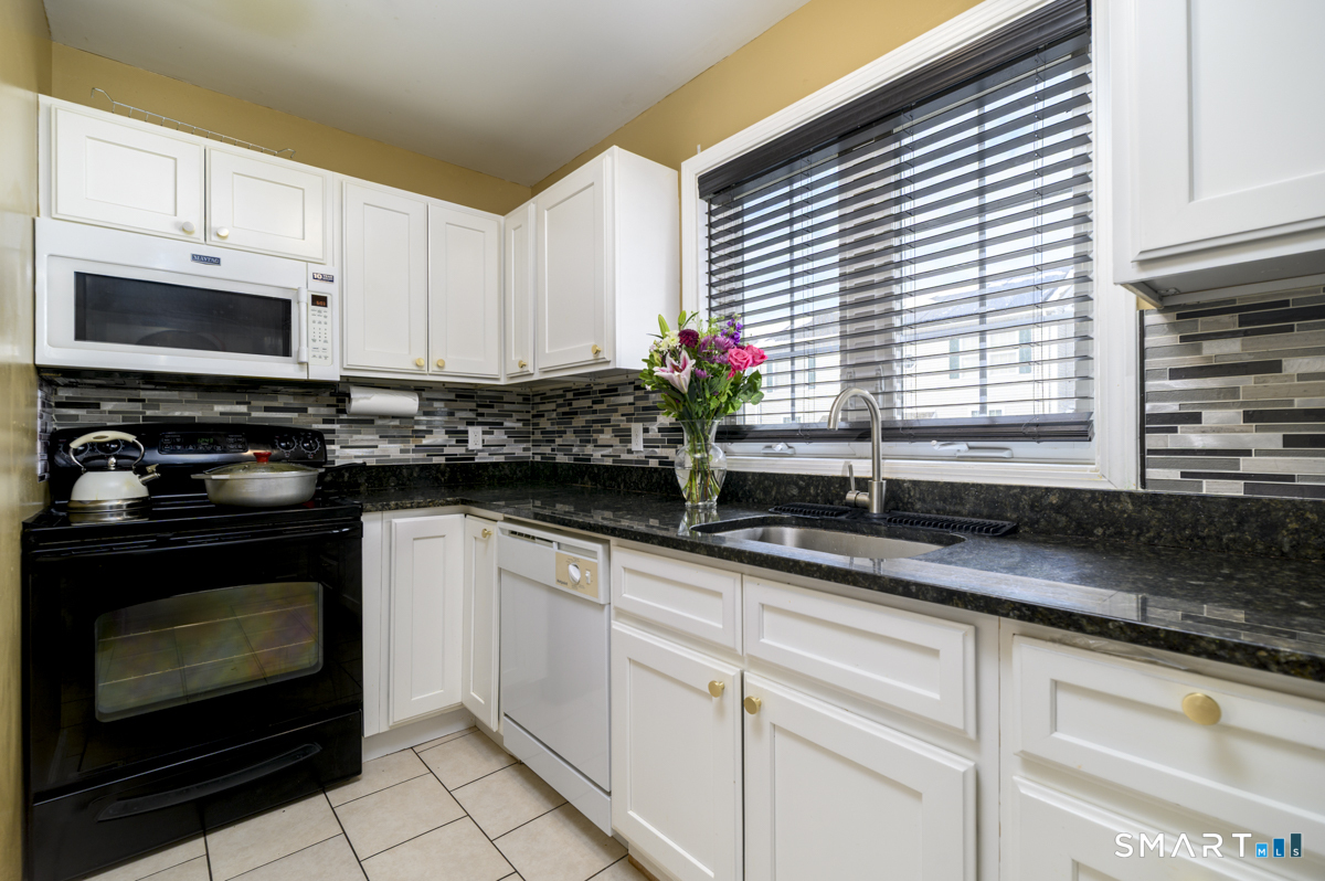 800 Seaview Avenue, Unit 8001 Bridgeport, CT 06607 - Photo 8 of 25 a kitchen with granite countertop a sink a stove and cabinets