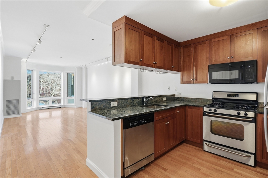 2-14 St Paul Street, Unit 403 Brookline, MA 02446 - Photo 1 of 16 a kitchen with stainless steel appliances granite countertop a stove a sink and a microwave