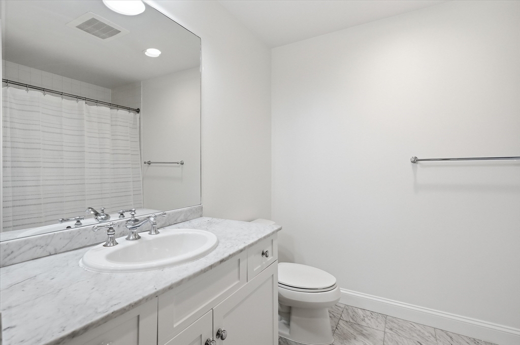 2-14 St Paul Street, Unit 403 Brookline, MA 02446 - Photo 7 of 16 a bathroom with a sink toilet and a mirror