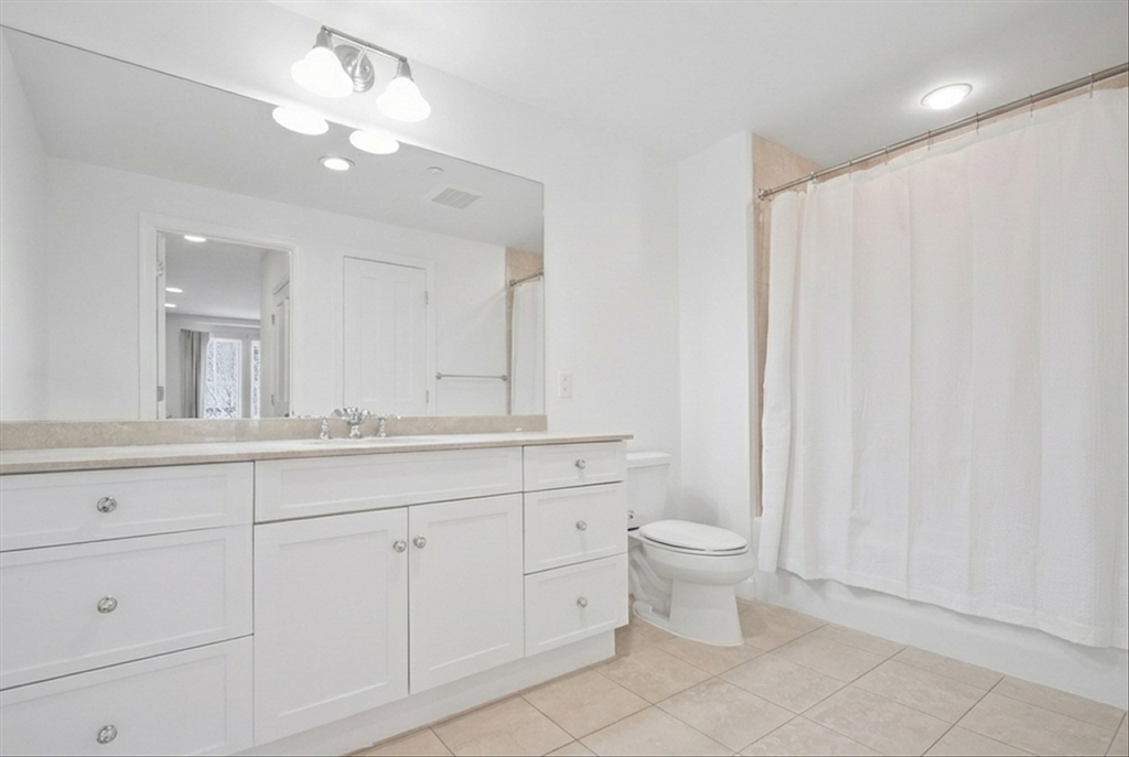 2-14 St Paul Street, Unit 403 Brookline, MA 02446 - Photo 9 of 16 a bathroom with 2 sink toilet and a mirror