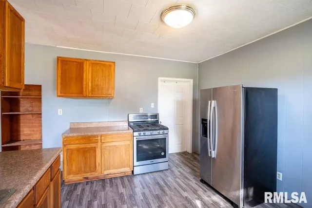 a kitchen with stainless steel appliances granite countertop a refrigerator and a stove top oven