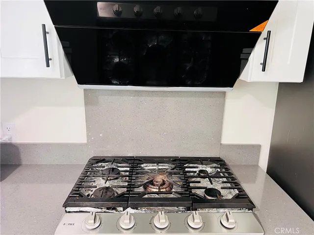 a kitchen with granite countertop a stove a sink and a refrigerator