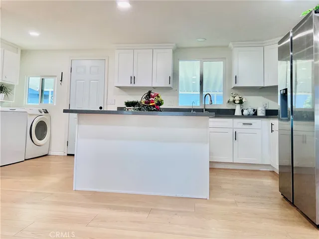 a large white kitchen with white cabinets and a stainless steel appliances