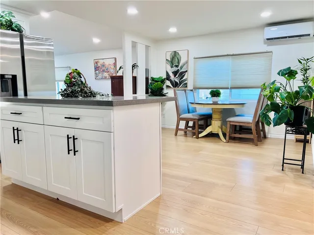 a dining room with furniture potted plants and wooden floor