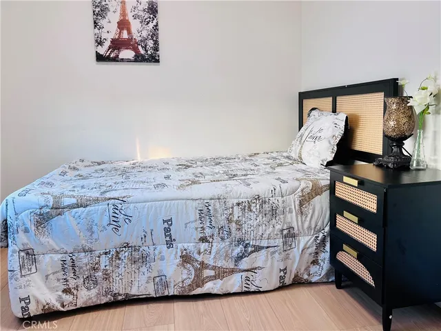 a bedroom with a large bed and wooden floor