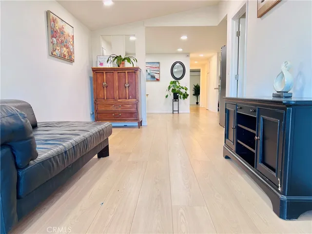 a living room with stainless steel appliances kitchen island granite countertop furniture and a wooden floor