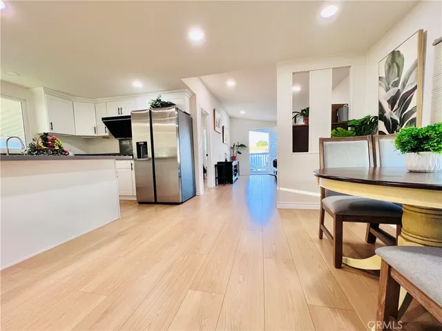 a kitchen with stainless steel appliances a stove top oven a sink a microwave a refrigerator and white cabinets