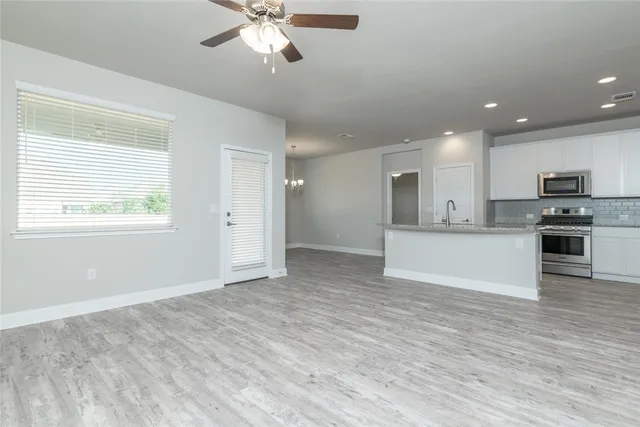 a view of kitchen with granite countertop cabinets and refrigerator