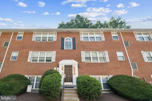 a front view of a multi story building with yard