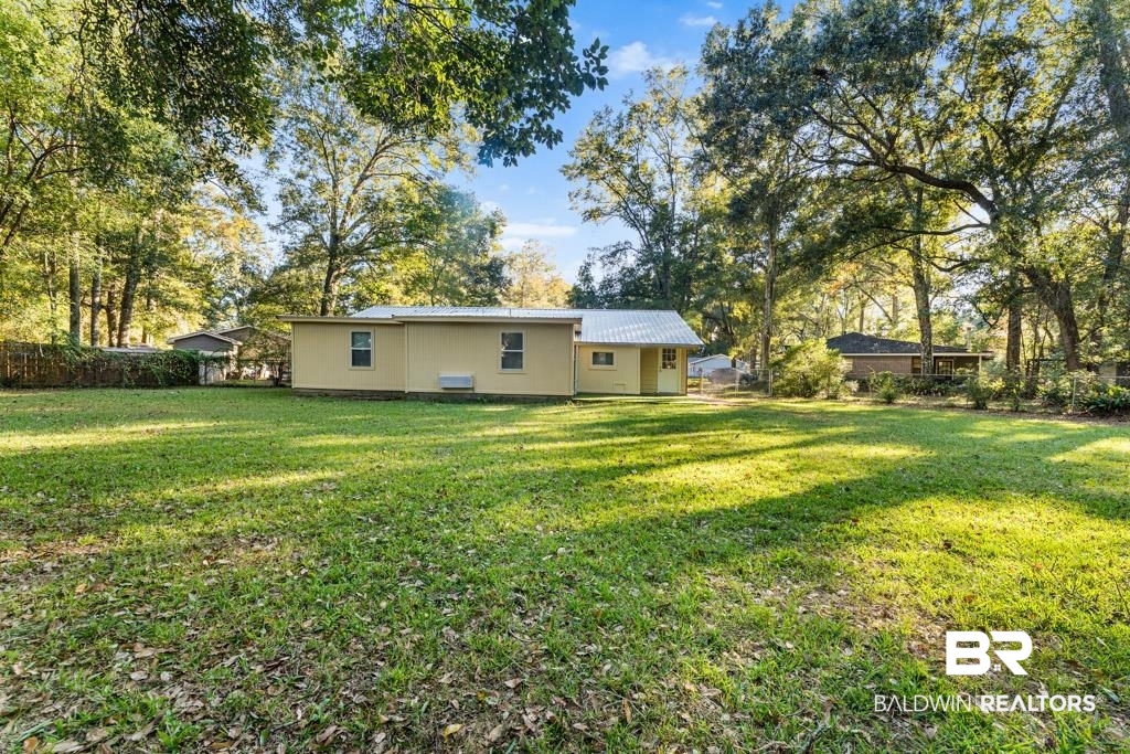 5551 Springer Court Theodore, AL 36582 - Photo 10 of 37 Back of house with a metal roof and view of scattered trees