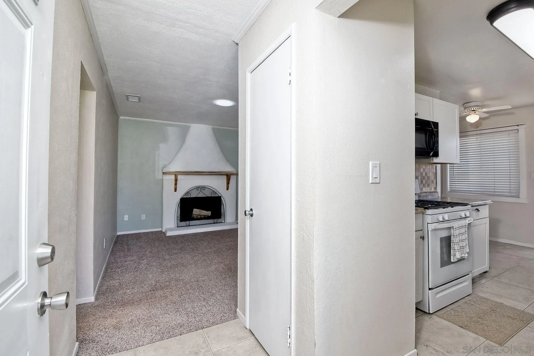 14135 Powers Road Poway, CA 92064 - Photo 12 of 35 a view of a kitchen with a sink a refrigerator and a fireplace