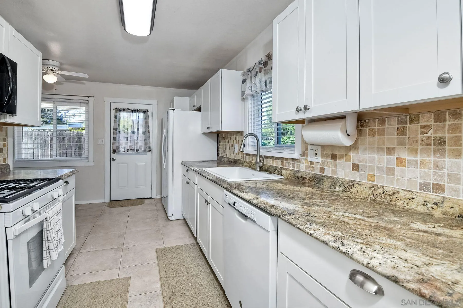 14135 Powers Road Poway, CA 92064 - Photo 6 of 35 a kitchen with granite countertop a sink a stove and cabinets