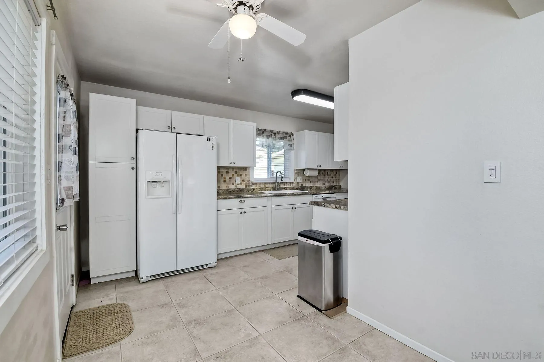 14135 Powers Road Poway, CA 92064 - Photo 10 of 35 a kitchen with white cabinets and refrigerator