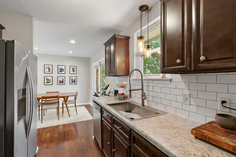 a kitchen with stainless steel appliances granite countertop a sink stove and refrigerator