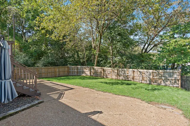 a view of a backyard with wooden fence
