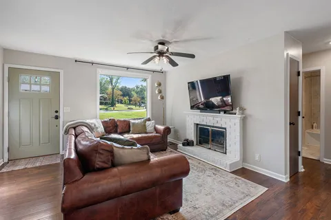 a living room with furniture a fireplace and a flat screen tv