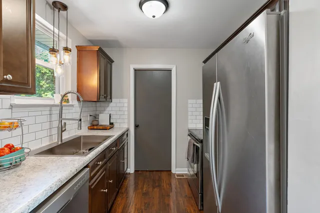 a kitchen with stainless steel appliances granite countertop a refrigerator and a sink