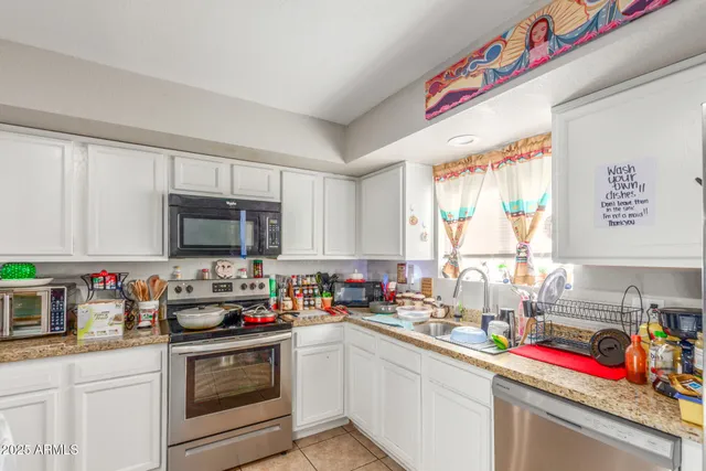 a kitchen with granite countertop lots of appliances and cabinets