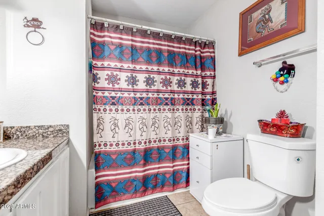 a bathroom with a sink toilet vanity and window