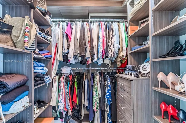 a view of walk in closet with clothes and shoes